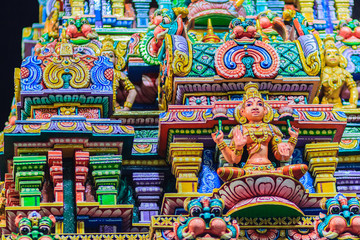 Obraz premium Colorful night view of indian gods sculpture at Sri Maha Mariamman Temple, also known as Maha Uma Devi temple, the public hindu temple in Silom, Bangkok, Thailand. It known as Wat Khaek Silom.