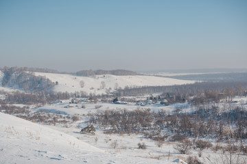 Winter view of the village from above. Houses in the snow. Countryside under the snow.