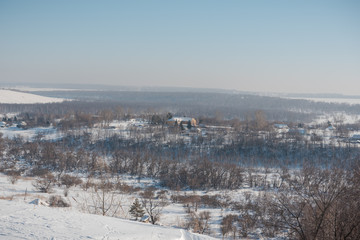 Fototapeta premium Winter view of the village from above. Houses in the snow. Countryside under the snow.