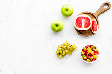 Healthy diet concept. Fruit salad near fresh fruits on white background top view copy space