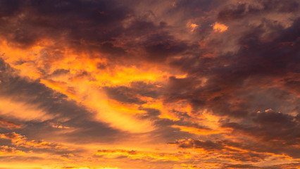 Naklejka na ściany i meble Colourful clouds at sunset. Dramatic exploding sunset. Fiery Sky. Beautiful stormy sky. Cloudy abstract background. Sunset colors.