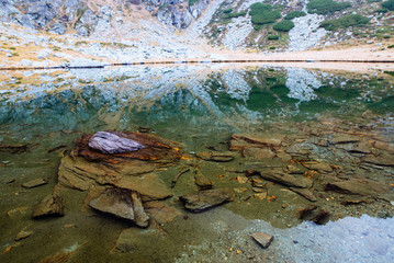 Fototapeta na wymiar A small lake with clear water in the middle of the mountains