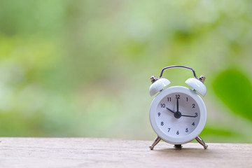 Retro pastel white alarm clock in outdoor atmosphere
