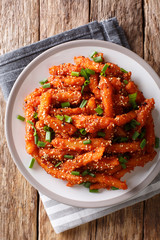 Crispy Honey Chilli Potatoes Delicious spicy snack on a plate close-up. Vertical top view