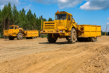 Pneumatic roller compacts the soil in the embankment on the road's construction. sand consolidation on road-building. Old compactor driving on the sandy roadbase. soil compacting machine