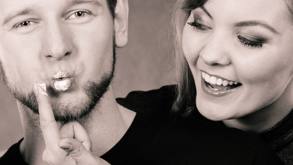 Young couple fooling with cream.