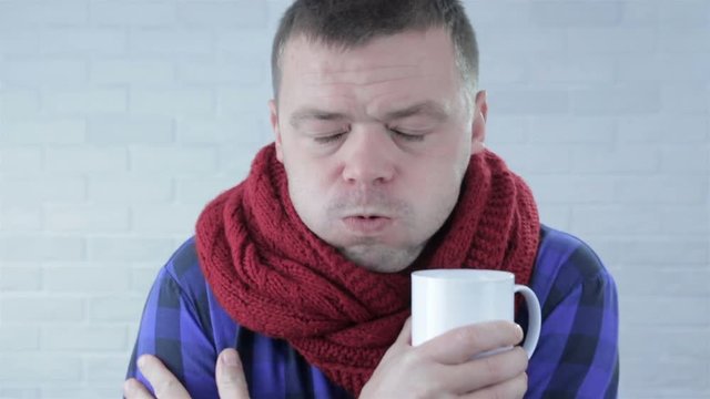 young man having cold on a wall