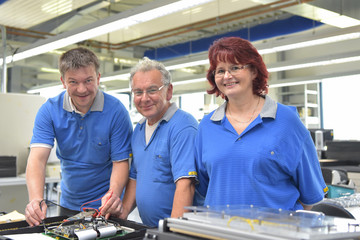 Gruppe Arbeiter in einer Fabrik zur Montage von Elektronik - Portrait glückliche Menschen am...