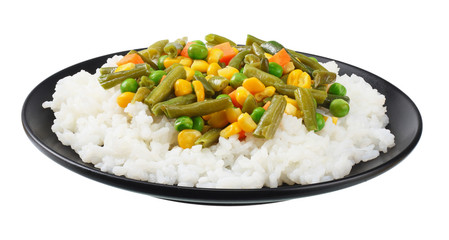 black plate with white rice, green peas, canned corn kernels, cut green beans isolated on white background