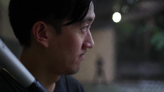 Confident Asian baseball batter waiting to strike the ball - Determined and focus concept