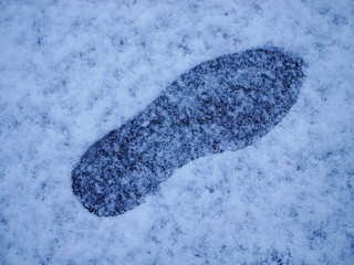 A single footstep / footprint in light snow 