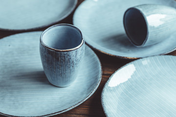Handmade blue set of ceramic tableware. Espresso cups and plates. - obrazy, fototapety, plakaty