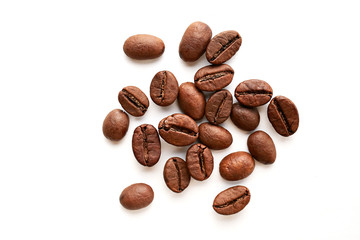 Roasted brown coffee beans scattered on white table with a lot copy space for text. Flat lay composition. Close up, top view, background.