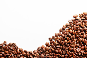 Roasted brown coffee beans scattered on white table with a lot copy space for text. Flat lay composition. Close up, top view, background.