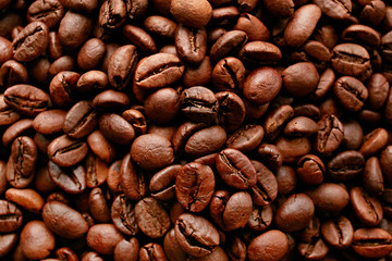 Freshly roasted coffee beans scattered on brown table with a lot copy space for text. Flat lay composition. Close up, top view, background. retro toned vintage filter.