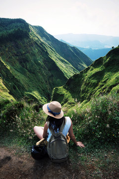 woman traveler holding hat and looking at amazing mountains and forest, wanderlust travel concept, space for text, atmospheric epic moment, azores, ponta delgada, sao miguel, stills wallpaper