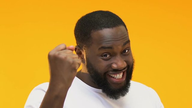 Excited Afro-American man showing yes gesture, happy lottery winner, close up