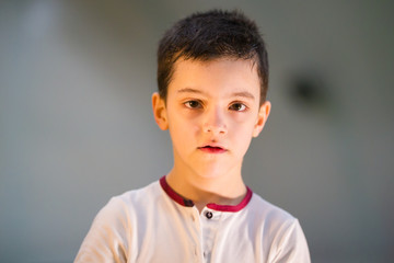 Obraz premium A little boy standing on the football field and looking directly at the camera after the game, portrait