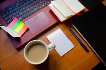 home office desk, red laptop, coffee, notebooks, diary, pen