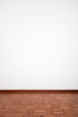 Room with brown wooden tiled floor and white blank wall