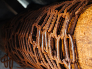 Ancient wooden well with a chain. Macro view of vintage old wooden well winch.