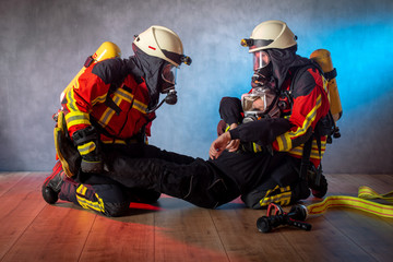 Fototapeta premium Feuerwehr, Atemschutztrupp im Einsatz, verletzte Person wird mit Rettungsgriff aus dem Gefahrenbereich gebracht