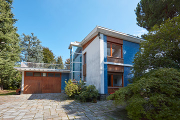 Fototapeta na wymiar Villa with garden and garage in a sunny summer day, clear blue sky