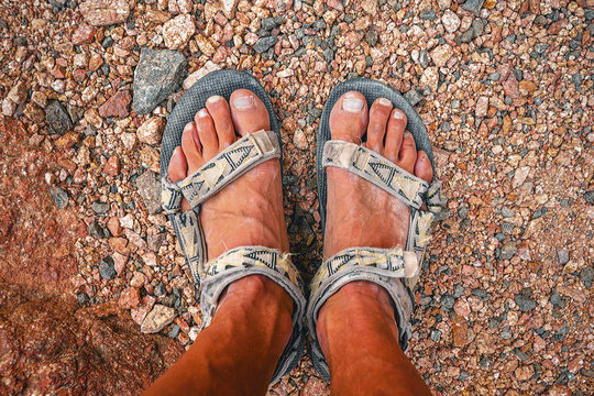 Man In Sandals After A Long Hike