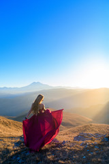 photo shoot in the mountains. girl in a dress against the mountains. at sunset