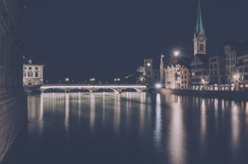 Naklejka premium Night view of historic Zurich city center with famous Fraumunster Church