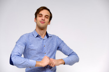 Concept studio portrait of a handsome young man isolated on a white background with different emotions in a blue shirt