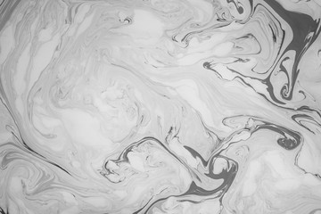 Abstract monochrome marble background. Stains of paint on the surface of the water.