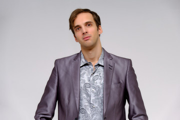 Studio concept Portrait of a handsome young man isolated on a white background with different emotions in a jacket and shirt in silver.
