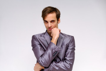 Studio concept Portrait of a handsome young man isolated on a white background with different emotions in a jacket and shirt in silver.