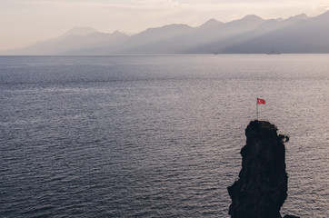 Fototapeta na wymiar Alone Turkey flag on the rock in Antalya, Turkey