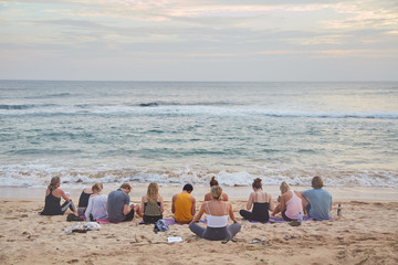 Fototapeta na wymiar A group of people doing yoga on the ocean. Sri-Lanka