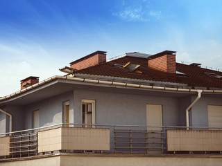 Modern, flat, block with a big balcony. Close-up with blue sky.