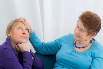Nachdenkliche Tochter zusammen mit Demenzkranken Mutter