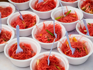 Pink noodles in styrofoam bowls