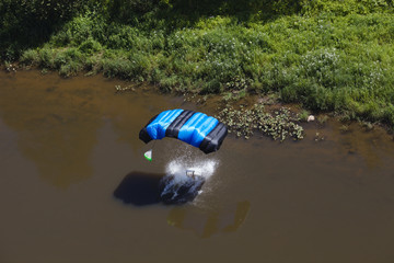 BASE jumper dropped into water near the river bank. View from above. - Powered by Adobe