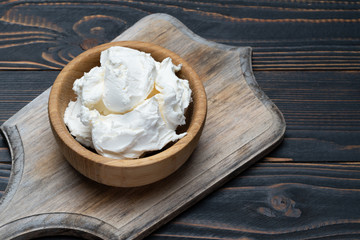 Traditional Mascarpone cheese in wooden bowl on table