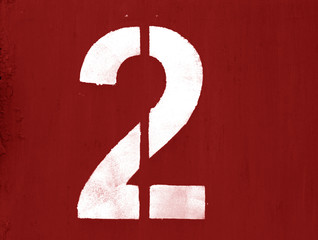 Number 1 in stencil on metal wall in red color.
