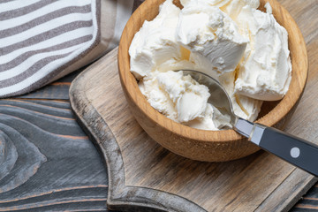 Traditional Mascarpone cheese in wooden bowl on table