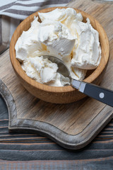 Traditional Mascarpone cheese in wooden bowl on table