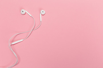 Headphones on pastel background. White headphones on a pink background. Top view. Flat lay. Copy space.