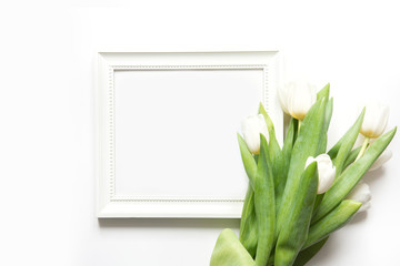 Frame for text and white tulip on white. Top view with copy space.