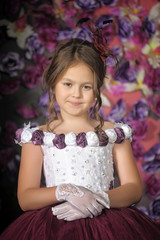 Girl in a purple dress on a floral background