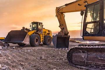 Group of excavator working on a construction site - obrazy, fototapety, plakaty
