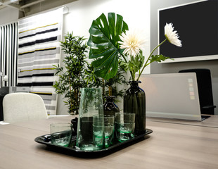Table in a Meeting room with flowers for decoration and TV, laptop computer.