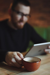 Man working at tablet PC in cafe